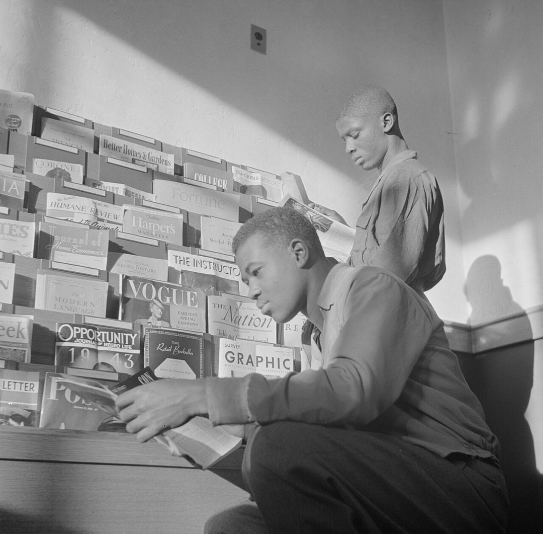 Étudiants assis à de longues tables dans la salle de lecture d'une bibliothèque universitaire en 1943.