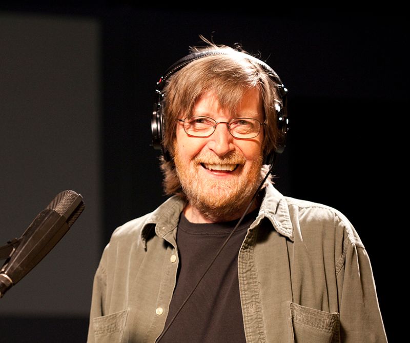 Larry Monroe assis au micro dans un studio de radio.