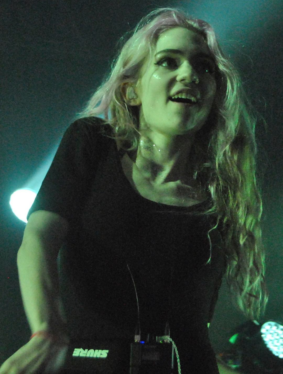 Grimes chantant sur scène lors d'un festival.