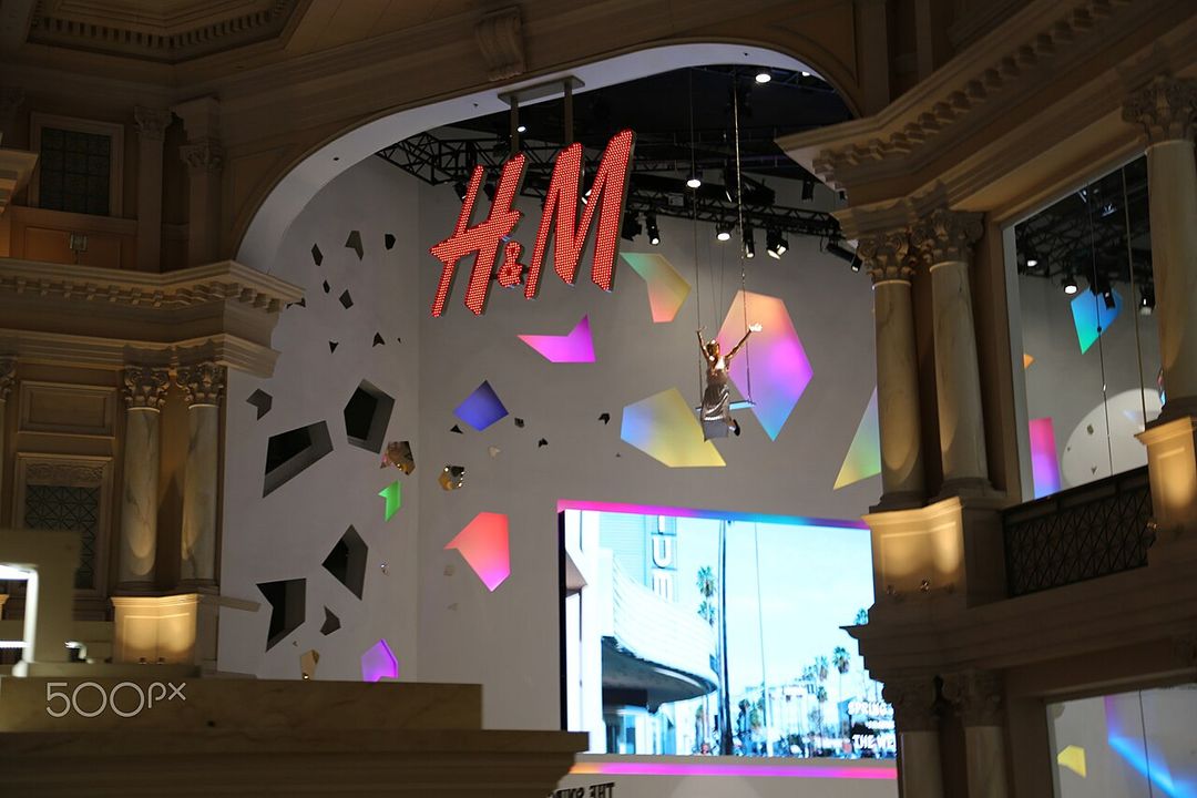 Façade illuminée d'une boutique H&M le soir.