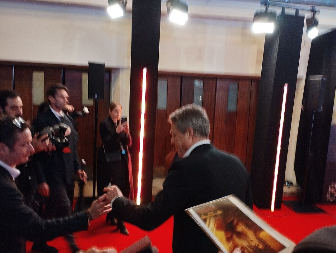 Hugh Grant souriant lors d'une avant-première.
