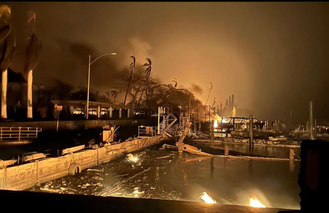 Vue aérienne de Lahaina en feu, avec d'épais panaches de fumée.