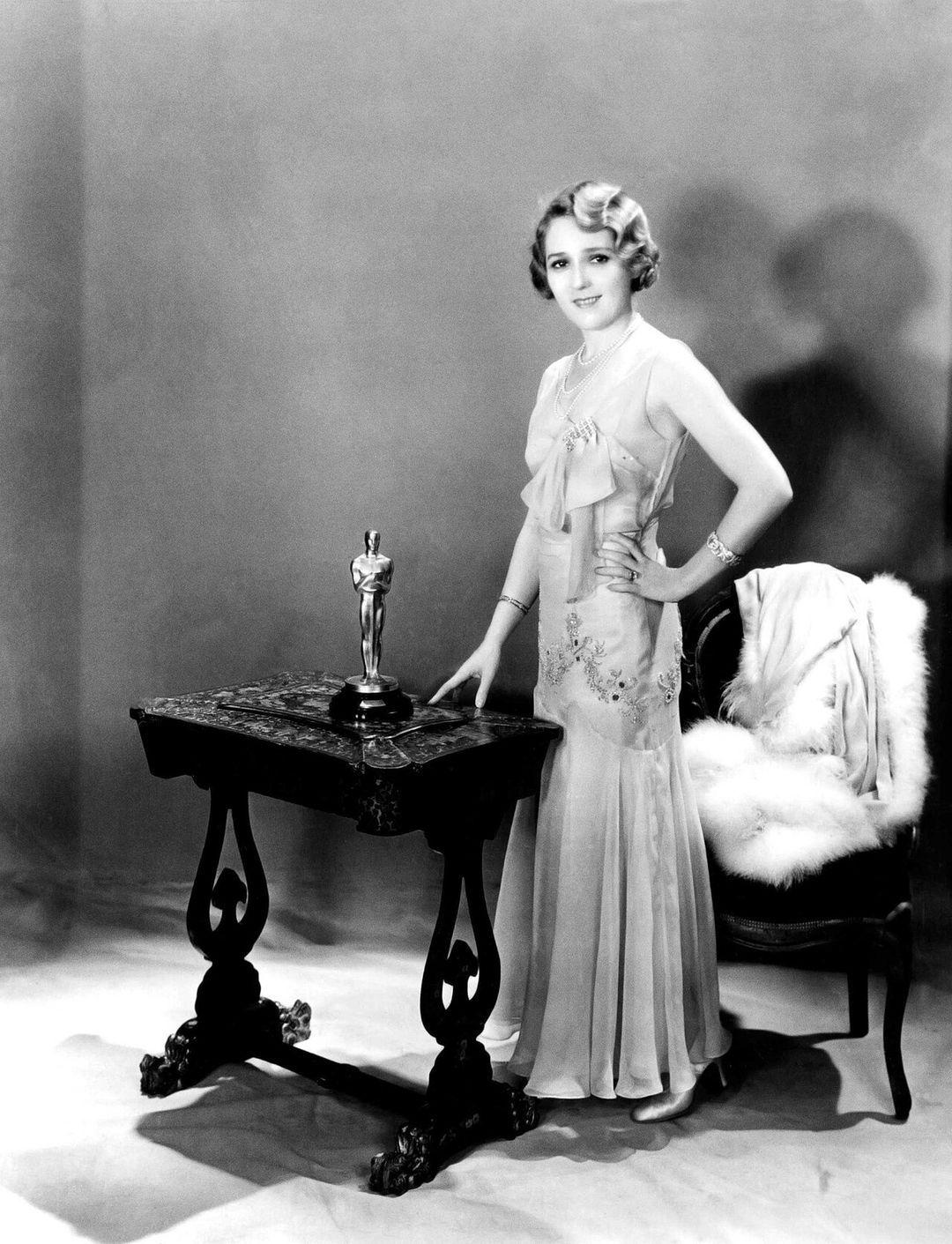Photographie en noir et blanc de l'actrice Mary Pickford tenant sa statuette des Oscars.