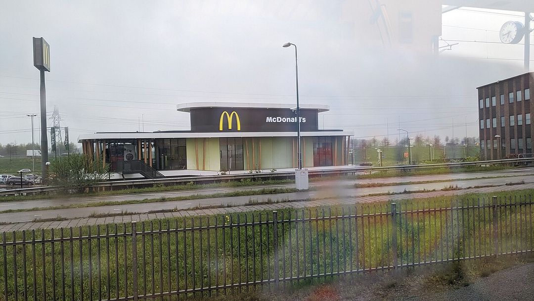 Restaurant McDonald's en briques avec son enseigne, au bord d'une route néerlandaise.