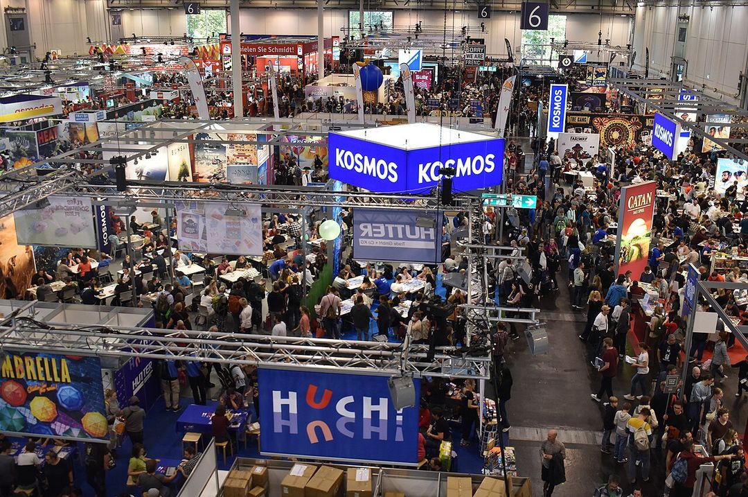Hall bondé du salon Spiel Essen avec des stands de jeux de société.